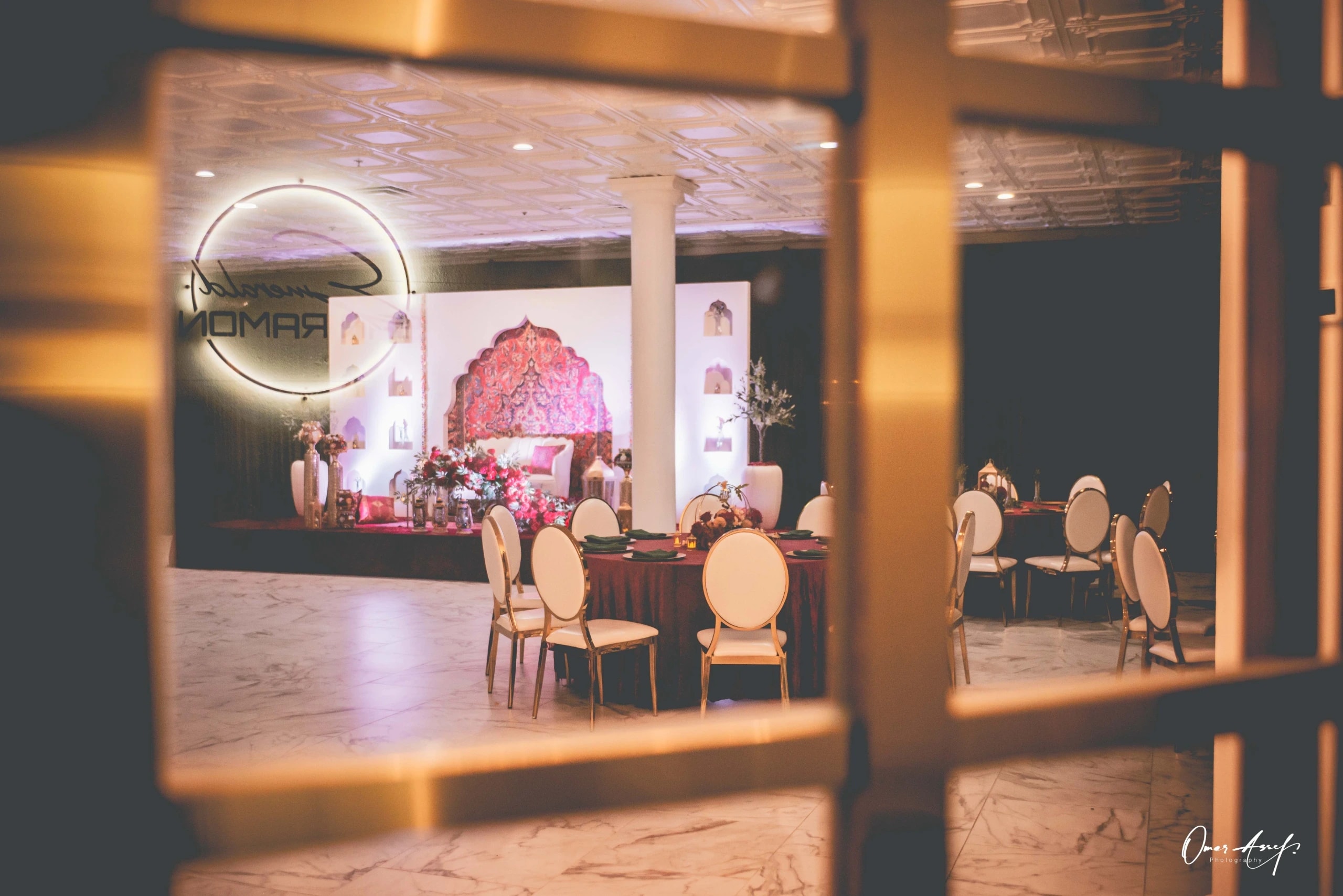 The hall lit warm, with blossom tree and bar